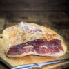 Demi jambon Serrano Gran Reserva avec os présenté sur planche en bois